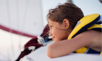 Young girl wearing a lifejacket on a sailboat