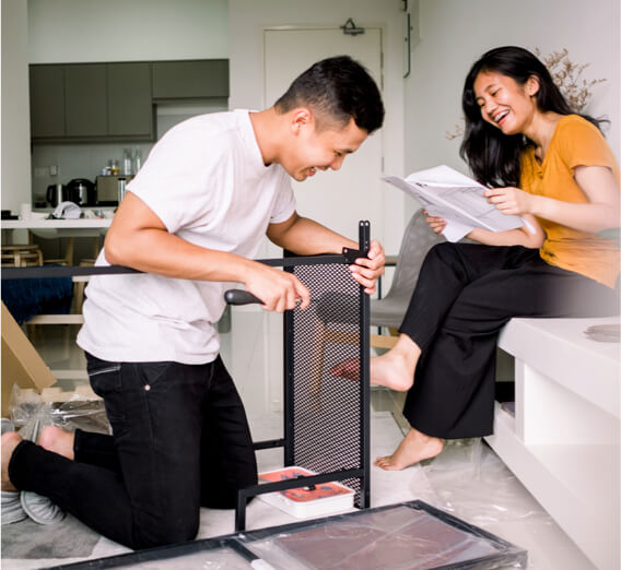 Smiling couple assembling furniture in living room
