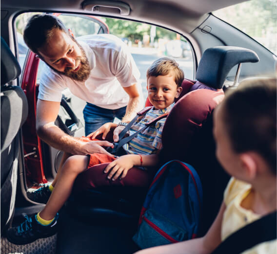 Père attachant un jeune enfant dans un siège d’auto
