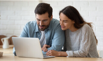 Couple utilisant un ordinateur portatif pour se magasiner des assurances.